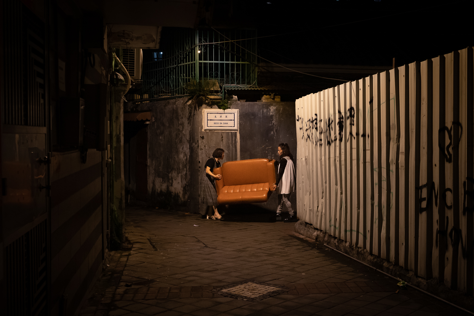 Moving house or a lucky find? Two residents carry a sofa on the Beco da Cana